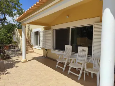 a patio with white chairs and a large window at Villa 3 Quartos, Piscina, AC, Vista Mar, Prestige For Home in Loulé
