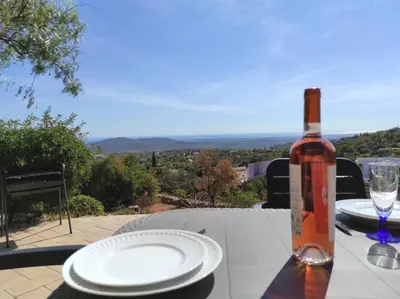a bottle of wine sitting on a table with plates at Villa 3 Quartos, Piscina, AC, Vista Mar, Prestige For Home in Loulé
