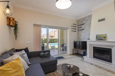 a living room with a couch and a fireplace at Real Alegria - Terrace with pool - Vilamoura in Vilamoura