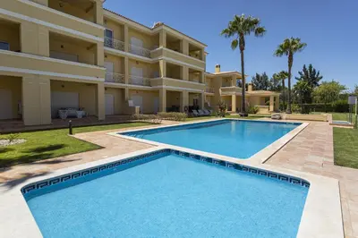 a villa with a swimming pool in front of a house at Real Alegria - Terrace with pool - Vilamoura in Vilamoura