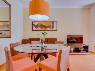 a dining room with a table and chairs and a tv at AL - Apartamento Vila Sol F5 P in Vilamoura