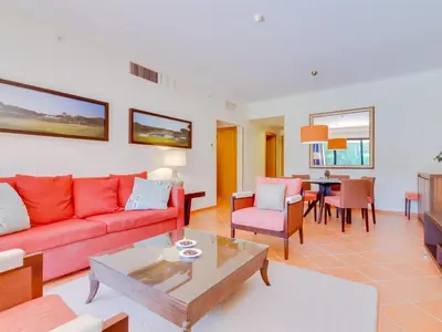 a living room with a red couch and a table at AL - Apartamento Vila Sol F5 P in Vilamoura