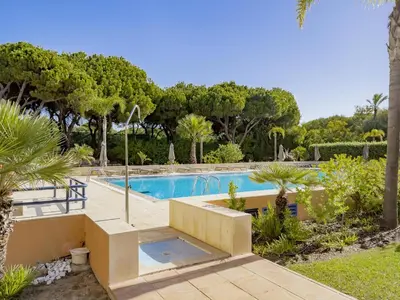 a swimming pool in a yard with trees at AL - Apartamento Vila Sol F5 P in Vilamoura