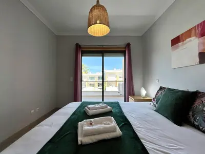 a bedroom with a large bed with two towels on it at Albufeira Garden Villa With Pool by Homing in Albufeira