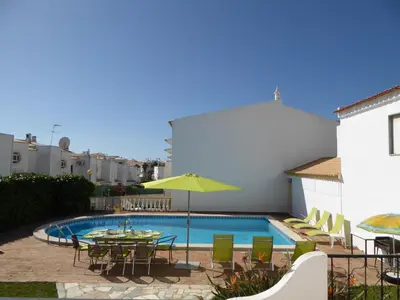 a swimming pool with a table and chairs next to a building at Vital by Check-in Portugal in Albufeira