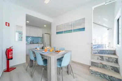 a kitchen and dining room with a table and blue chairs at Casa da Bateria by HelloVacations in Albufeira