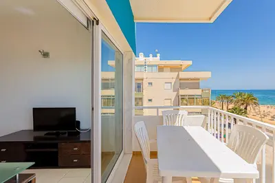 a balcony with a white table and chairs and the ocean at Frente praia SIM T3 Praia Quarteira by HsRentals in Quarteira