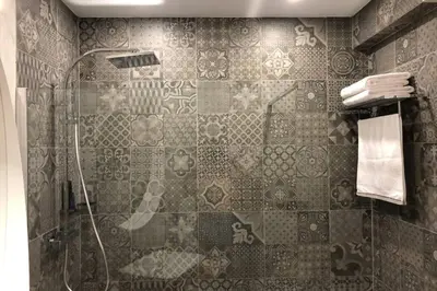 a bathroom with a shower with a tile wall at Le Modern' in Albufeira