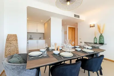 a dining room with a wooden table and chairs at Varandas do Castelo By Garvetur in Albufeira