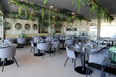 a dining room with tables and chairs and plants at Varandas do Castelo By Garvetur in Albufeira