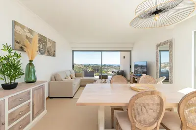 a living room with a dining room table and chairs at Varandas do Castelo By Garvetur in Albufeira