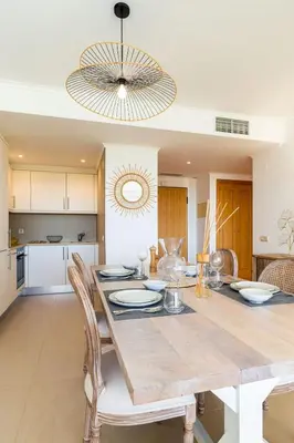 a dining room and kitchen with a table and chairs at Varandas do Castelo By Garvetur in Albufeira