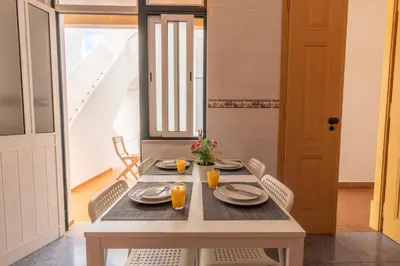a dining room table with plates and orange juice at GrowIN Digital Nomads in Faro
