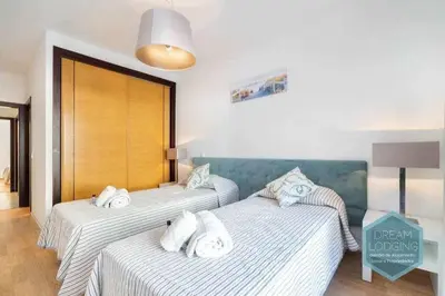 two beds in a hotel room with towels on them at Terrace Miguel Torga - Dream Lodging in Albufeira