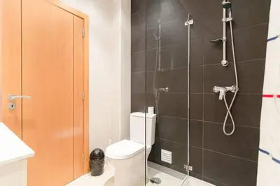 a bathroom with a shower with a toilet and a sink at De Hofnar Apartments Albufeira in Albufeira