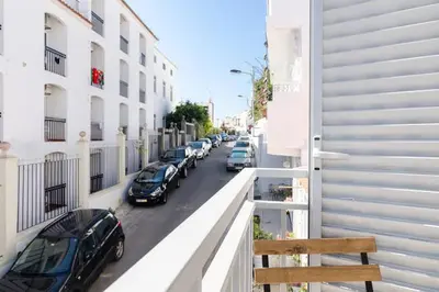 a row of cars parked on a street next to buildings at De Hofnar Apartments Albufeira in Albufeira