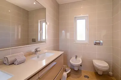 a bathroom with a sink and a toilet and a mirror at Casa Tulipas in Loulé