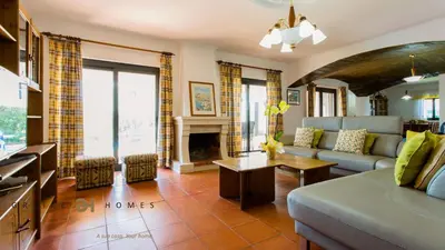a living room with a couch and a fireplace at Greice Homes-650 meters from the beach, 4 bedrooms villa for holidays in Vilamoura-Quarteira in Quarteira