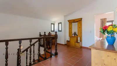 a hallway with a staircase and a vase of flowers at Greice Homes-650 meters from the beach, 4 bedrooms villa for holidays in Vilamoura-Quarteira in Quarteira