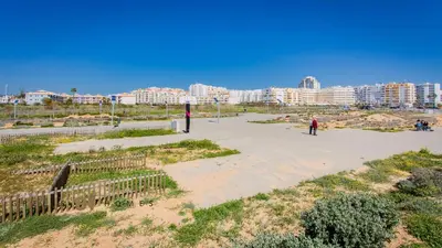 a person is playing baseball in a park with buildings at Greice Homes-650 meters from the beach, 4 bedrooms villa for holidays in Vilamoura-Quarteira in Quarteira