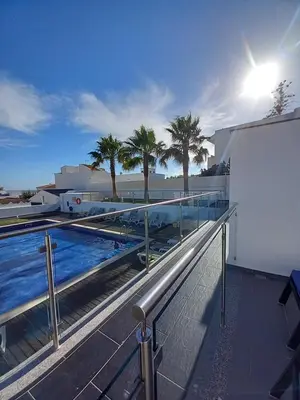a balcony with a pool and palm trees on a building at Villa beautiful View over the sea - T in Albufeira