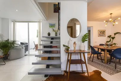 a staircase in a living room with a table and chairs at Casa Lobo - 2 bedrooms - Duplex in Faro