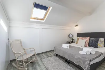 a bedroom with a bed and a chair and a window at Casa Lobo - 2 bedrooms - Duplex in Faro