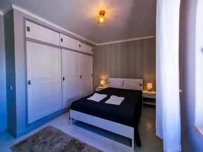 a small bedroom with a bed and a white door at FLH Vilamoura Balcony with Pool in Vilamoura