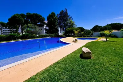 a large swimming pool in a yard with a grass field at FLH Vilamoura Balcony with Pool in Vilamoura