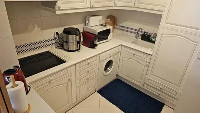 a small kitchen with white cabinets and a washer and dryer at Tivoli Apt8 with Pool&Garage in Vilamoura
