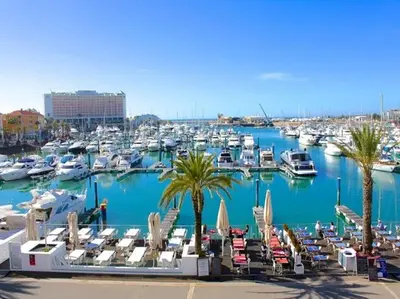 a marina with chairs and boats in a harbor at Tivoli Apt8 with Pool&Garage in Vilamoura