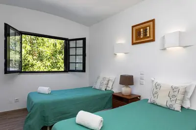 two beds in a room with a window at The Albufeira Concierge - Villa Balaia Sun Terrace in Albufeira