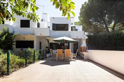 a patio with a table and an umbrella in front of a building at The Albufeira Concierge - Villa Balaia Sun Terrace in Albufeira