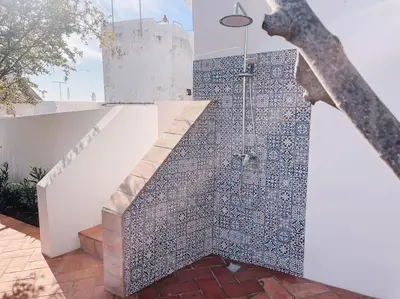 a bathroom with a walk in shower next to a staircase at Old Fisherman's Corner 18 - Centro Old Town Albufeira in Albufeira