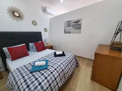 a bedroom with a bed with red and blue pillows at Sun Apartment on the Beach in Albufeira