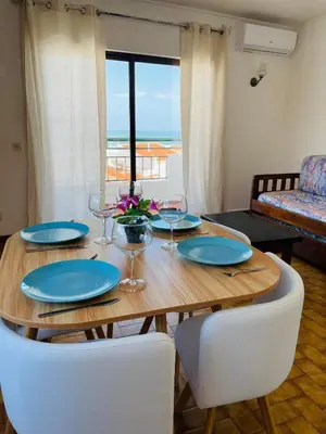 a wooden table with plates and wine glasses on it at Casa Do Canto in Albufeira