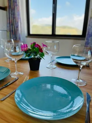a table with two wine glasses and a flower on it at Casa Do Canto in Albufeira