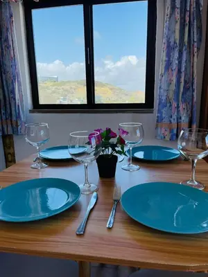 a table with plates and glasses on a wooden table at Casa Do Canto in Albufeira