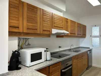 a kitchen with wooden cabinets and a counter top at Velamar Praia 411 - 300m da praia in Albufeira