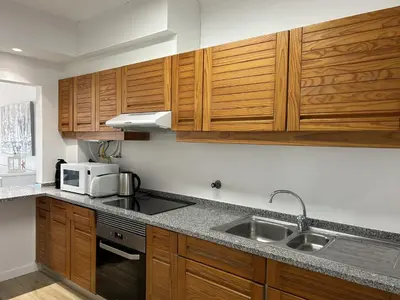 a kitchen with wooden cabinets and a microwave at Velamar Praia 411 - 300m da praia in Albufeira