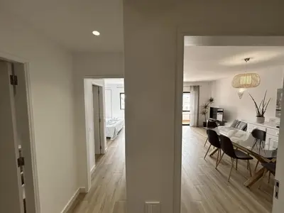 a living room with a table and chairs and a kitchen at Velamar Praia 411 - 300m da praia in Albufeira