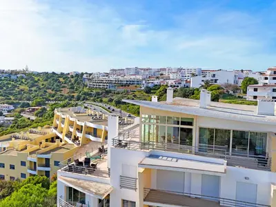 a dining room with a table with white flowers on it at AlbufeiraOrada SunSet Penthouse by Be Cherish in Albufeira