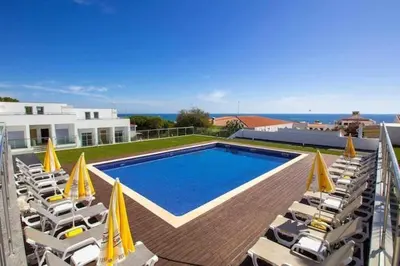 a swimming pool with chairs and umbrellas on a house at Villa Amazing View - S in Albufeira
