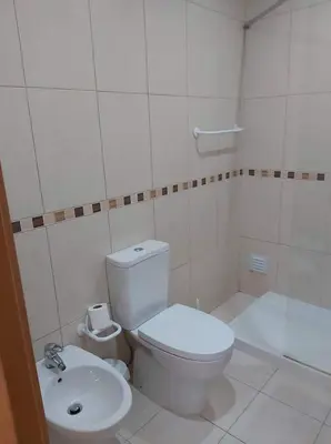 a white bathroom with a toilet and a sink at Terrace apartament on the Sea in Albufeira
