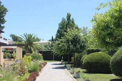 a garden with trees and bushes and a pathway at Algarve Paraíso / Golf Vila Sól in Quarteira