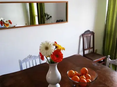 a vase with flowers and oranges on a table at Lemon Tree Apartments in Faro