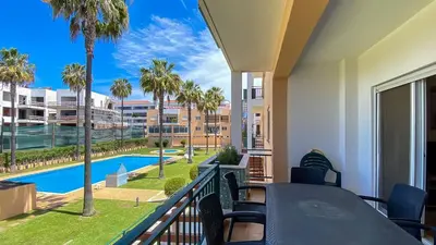 a balcony with a view of a pool and palm trees at T3 Marina Sol Vilamoura by HsRentals in Vilamoura