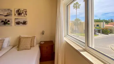 a bedroom with a bed and a chair and a window at T3 Marina Sol Vilamoura by HsRentals in Vilamoura