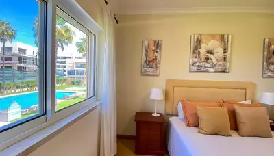 two twin beds in a room with a window at T3 Marina Sol Vilamoura by HsRentals in Vilamoura