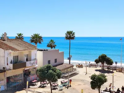 a building on the beach next to the ocean at Beach Condo with Atlantic Ocean View by BeCherish in Olhos de Água